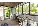 Relaxing sunroom with large windows offering serene views, a table with chairs, and comfortable decor at 5241 Guilford Ave, Indianapolis, IN 46220
