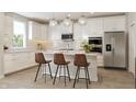 Bright kitchen with white cabinets, stainless steel appliances, granite countertops and modern globe pendant lighting at 5774 Cloister Ln, McCordsville, IN 46055