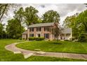 Traditional brick home featuring classic architecture, a welcoming porch, and a beautifully landscaped yard at 5800 Lawrence Dr, Indianapolis, IN 46226