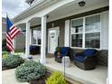 Inviting front porch with cozy seating, decorative pillows, and an American flag at 6309 Harvey Dr, Plainfield, IN 46168
