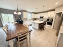 Open-concept kitchen and dining area with an island, white cabinetry, and stainless steel appliances at 6309 Harvey Dr, Plainfield, IN 46168
