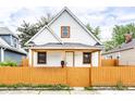 Charming two-story home with a bright yellow fence and inviting front porch at 647 Coffey St, Indianapolis, IN 46221