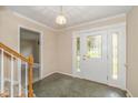 Inviting foyer features slate flooring, leaded glass door, and access to staircase at 6530 Kingswood Dr, Indianapolis, IN 46256