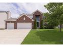 Charming two-story brick home with a well-manicured lawn, mature tree, and an attached two-car garage at 6839 Powder Dr, Indianapolis, IN 46259