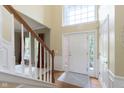 Bright foyer featuring hardwood floors, white trim, and a staircase leading to the upper level of the home at 6839 Powder Dr, Indianapolis, IN 46259