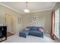 Comfortable living room with a blue sectional sofa, neutral walls, and a bright window for natural light at 6839 Powder Dr, Indianapolis, IN 46259