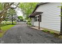 Home exterior with a long driveway leading to a detached garage and a pergola-covered side entrance at 7228 Kimberly Ln, Plainfield, IN 46168