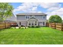 Spacious backyard with a patio, grilling area, fenced in yard, and lush green lawn at 8704 New Heritage Dr, Indianapolis, IN 46239
