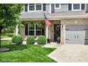 Inviting front porch with seating and lush landscaping, including an American flag at 8704 New Heritage Dr, Indianapolis, IN 46239