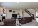 Spacious living room with comfortable seating, a fireplace, staircase, and ample natural light at 8732 Wicklow Way, Brownsburg, IN 46112
