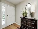 Inviting foyer with a decorative mirror, stylish cabinet, and a bright, welcoming entrance door at 9324 W Point Pl, Indianapolis, IN 46268