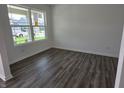 Well-lit living room featuring luxury vinyl plank flooring and white walls at 11302 N Quillow Way, Monrovia, IN 46157