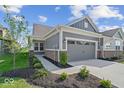 Charming single-story home featuring a two-car garage, landscaped yard, and modern exterior at 11469 Lottie Cir, Noblesville, IN 46060