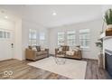 Bright living room with a fireplace, wood floors, and large windows at 11469 Lottie Cir, Noblesville, IN 46060