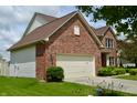Brick house showing the side, including the garage and landscaping at 11850 Stepping Stone Dr, Fishers, IN 46037