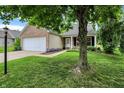 Beautiful single-story home with a manicured lawn and mature tree providing ample shade at 12257 Driftstone Dr, Fishers, IN 46037