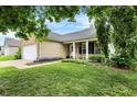 Well-kept home featuring a lush green lawn, colorful landscaping, and charming front porch at 12257 Driftstone Dr, Fishers, IN 46037