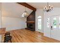 Bright living room features hardwood floors, a skylight, and a striking brick fireplace with a rustic wood beam at 12290 Charing Cross Rd, Carmel, IN 46033