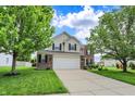 Traditional two-story home with brick and siding exterior and a spacious driveway at 13209 Westwood Ln, Fishers, IN 46038