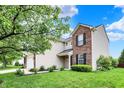 This two-story home is framed with mature landscaping and a mix of siding and brick at 13209 Westwood Ln, Fishers, IN 46038