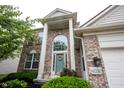 Detailed view of the home's entrance, showcasing the brick facade, columns, and arched window at 14030 Avalon East Dr, Fishers, IN 46037