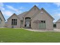 Beautiful brick home with a manicured lawn, showcasing the front entrance and landscaping at 14035 Stone Key Way, Fishers, IN 46040