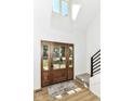 Bright foyer featuring a striking front door with glass panels, contemporary black railing, and an abundance of natural light at 14728 Adios Pass, Carmel, IN 46032