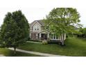 Charming two-story home with a well-manicured lawn and mature trees at 1476 Anon Ct, Greenwood, IN 46143