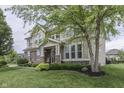 Two-story home with a stone and siding exterior, complemented by a lush green lawn and mature trees at 1476 Anon Ct, Greenwood, IN 46143