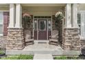 Inviting front porch with stone pillars, hanging flower baskets, and comfortable seating at 1476 Anon Ct, Greenwood, IN 46143
