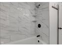 Stylish bathroom with marble tile shower, built-in shelves, and updated fixtures at 1517 Wallace Ave, Indianapolis, IN 46201
