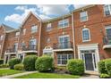 Beautiful red brick townhouse exterior with black iron balconies and manicured green landscaping at 15369 Mystic Rock Dr, Carmel, IN 46033