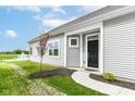 Inviting single-story home entrance with a walkway, black front door, and a view of a pond with a fountain at 1829 James Pierce Dr, Shelbyville, IN 46176