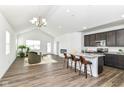 Open-concept living space with vaulted ceilings, wood floors, and a kitchen island with bar seating at 1829 James Pierce Dr, Shelbyville, IN 46176