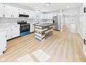 Modern kitchen with white cabinets, stainless steel appliances, and unique island at 225 S Carthage Rd, Charlottesville, IN 46117