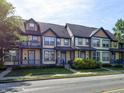 Charming multi-Gathering exterior featuring a light yellow facade and blue accents, complemented by lush greenery and a well-manicured lawn at 2260 Central Ave, Indianapolis, IN 46205