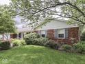 Well-maintained brick home boasting lush landscaping and mature trees, perfect for curb appeal at 31 N Restin Rd, Greenwood, IN 46142