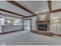 Cozy living room with exposed beams, brick fireplace, and open access to the kitchen at 31 N Restin Rd, Greenwood, IN 46142