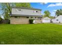 A charming two-story home with stone and siding exterior, complemented by a spacious green front lawn at 3425 N Elizabeth St, Indianapolis, IN 46226