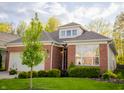 Well-maintained brick home featuring mature landscaping and a manicured lawn at 3438 Windy Knoll Ln, Carmel, IN 46074