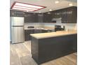 Kitchen featuring stainless steel appliances, a breakfast bar, and dark cabinets at 3453 Payton Ave, Indianapolis, IN 46226