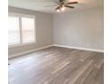 Bright living room featuring stylish gray wood flooring, a ceiling fan, and large windows at 3453 Payton Ave, Indianapolis, IN 46226