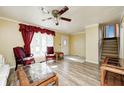 Comfortable living room with a staircase view, featuring stylish seating, ceiling fan and bright natural light at 3514 Eisenhower Dr, Indianapolis, IN 46224