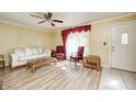 Inviting living room featuring wood floors, bright window, ceiling fan, and stylish furniture at 3514 Eisenhower Dr, Indianapolis, IN 46224