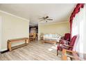 Spacious living room with light wood flooring, ceiling fan, with a dining room visible in the background at 3514 Eisenhower Dr, Indianapolis, IN 46224