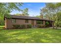 Charming brick ranch with manicured lawn, mature trees, and attached two-car garage at 3605 Redfern Dr, Indianapolis, IN 46237