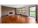 Bright living room featuring hardwood floors, brick fireplace, and large windows at 3605 Redfern Dr, Indianapolis, IN 46237