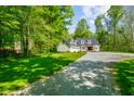 Traditional home featuring an attached garage, lush green lawn, and mature trees at 3660 S Conservation Club Rd, Morgantown, IN 46160