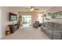 Cozy living room with plush reclining sofa, arm chair, ceiling fan, and large windows at 4281 Cairo Way, Avon, IN 46123