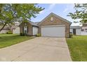 Lovely brick home featuring an attached two car garage, nice landscape, and spacious driveway at 4615 Copper Grove Dr, Indianapolis, IN 46237